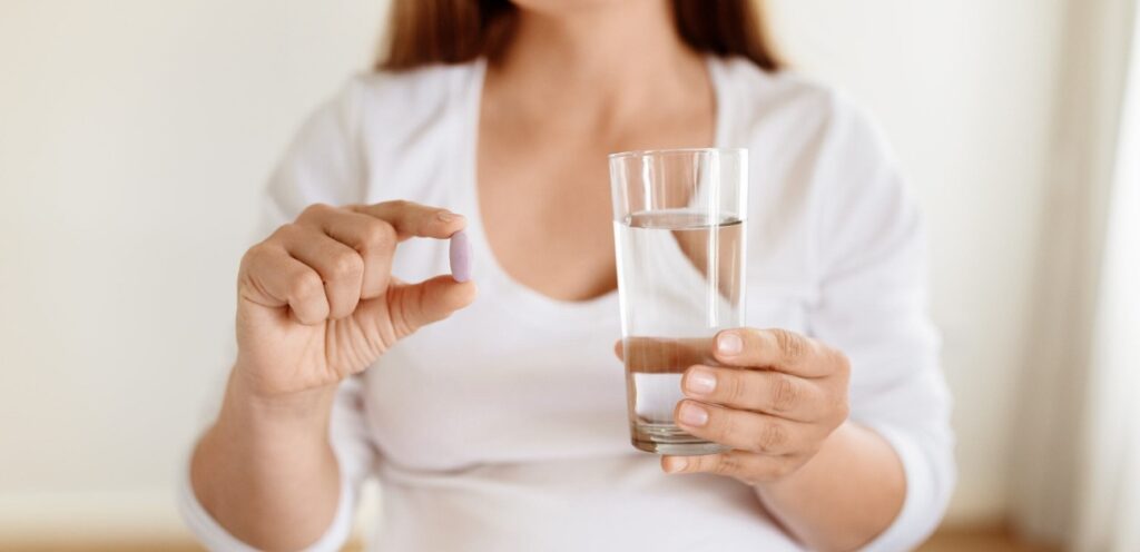 امرأة حامل تمسك حبوب دواء