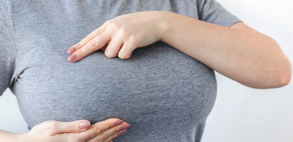 امرأة تضع يديها على ثديها