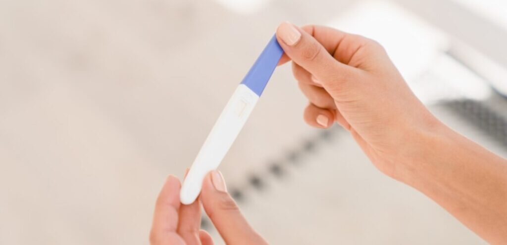 امرأة تمسك اختبار حمل