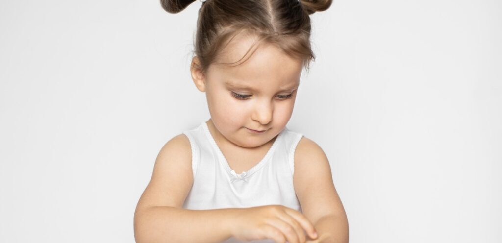 طفلة تنظر إلى يديها