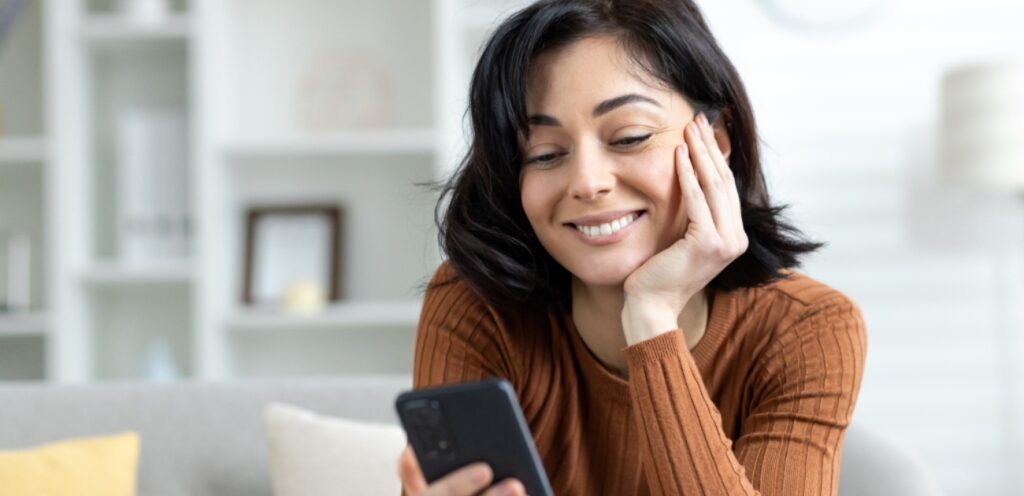 امرأة سعيدة تمسك جوّالها