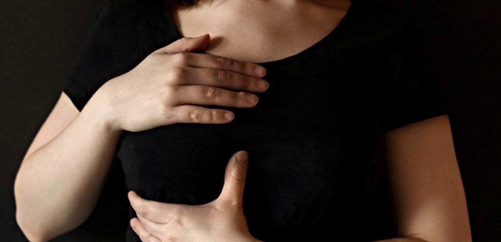 امرأة تضع يديها على ثديها