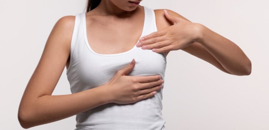 امرأة تضع يديها على ثديها