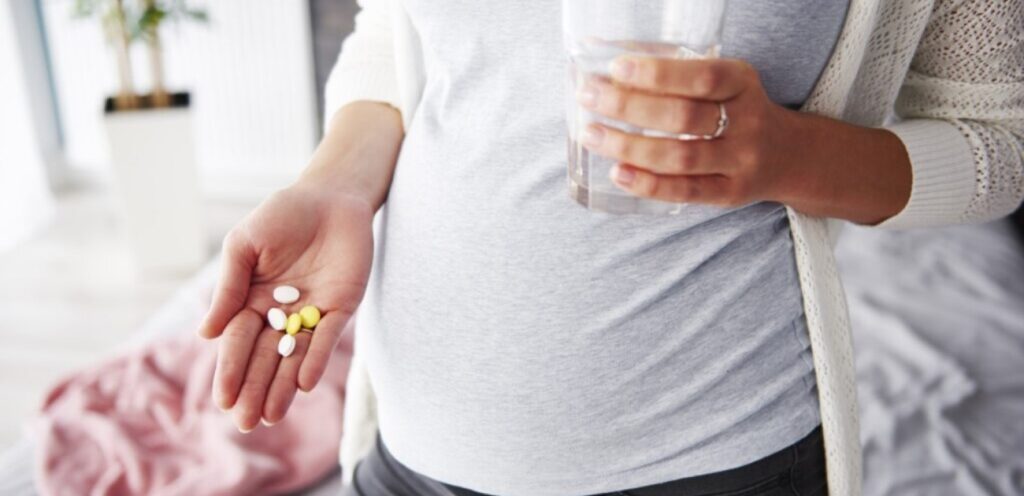 امرأة حامل تمسك حبوب من الدواء