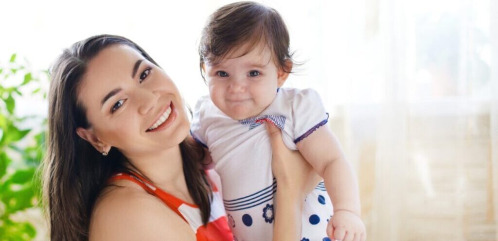 امرأة سعيدة تحمل رضيعتها