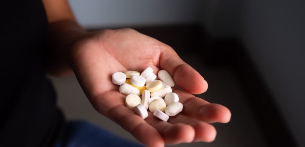 امرأة تمسك حبوب دواء