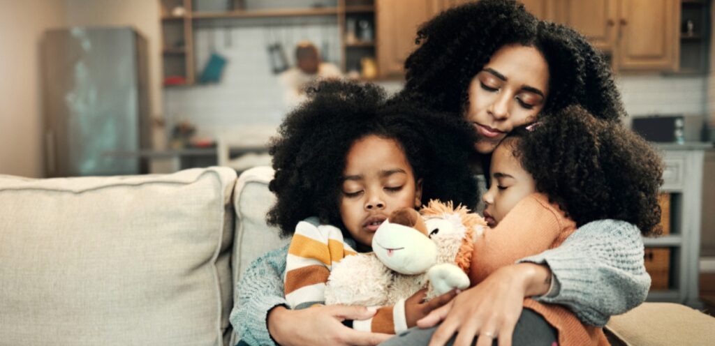 امرأة تحضن اطفالها