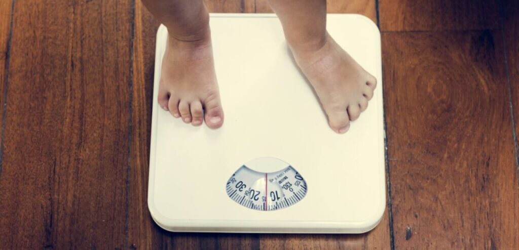 طفل يقف على الميزان