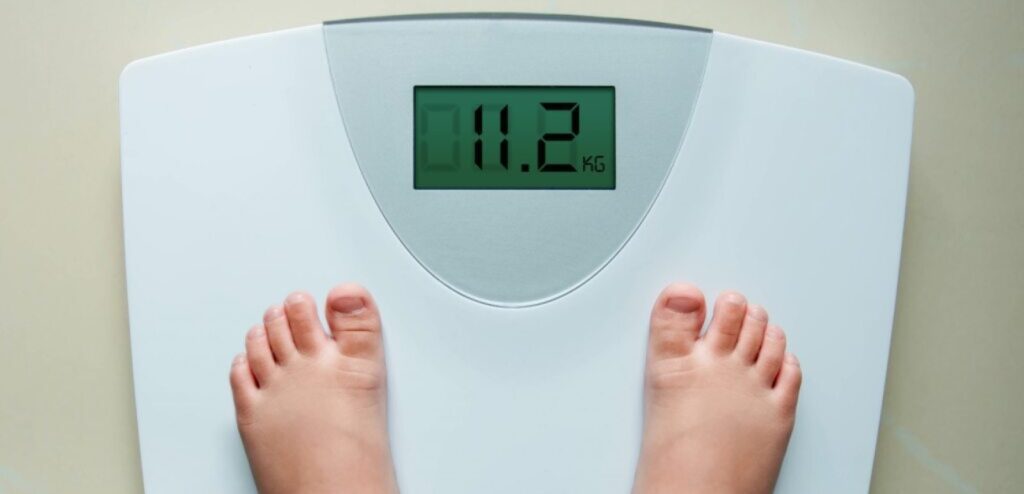 طفل يقف على الميزان