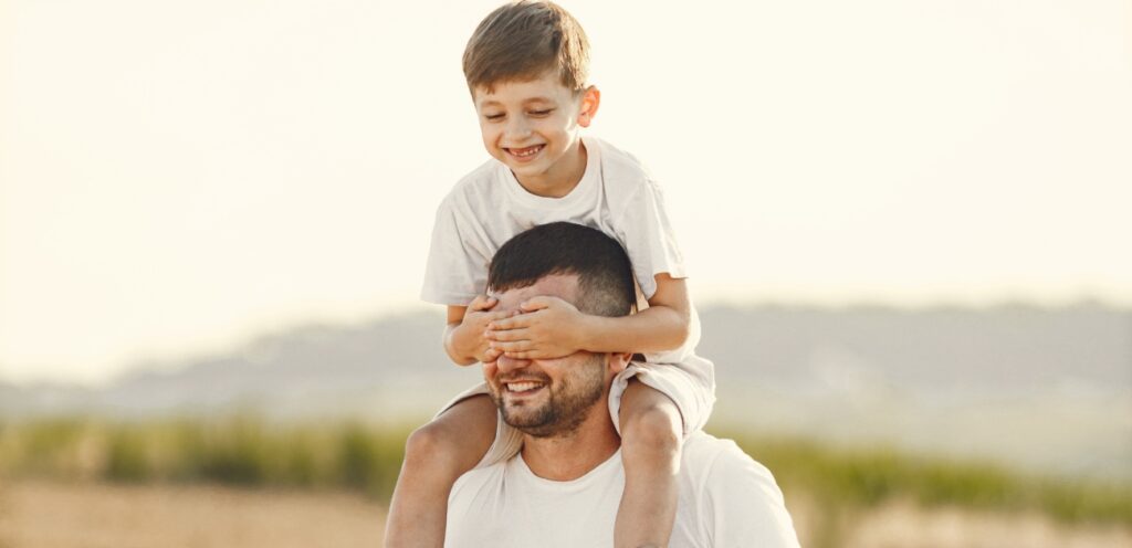 أب يحمل طفله على كتفيه