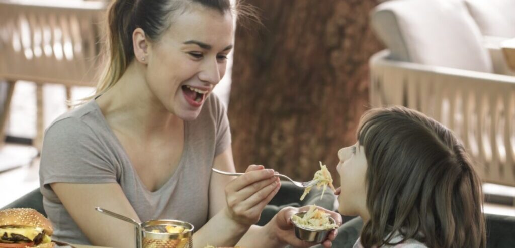 امرأة تأكل مع طفلتها