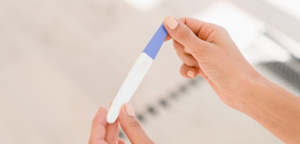 امرأة تمسك اختبار حمل