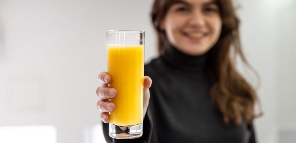 امرأة سعيدة تمسك كوب من العصير