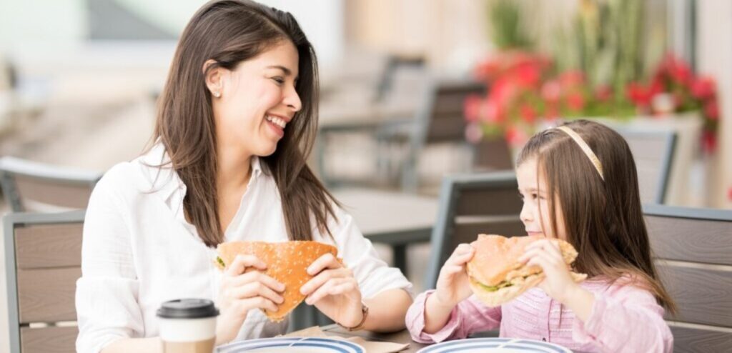 امرأة تأكل مع طفلتها