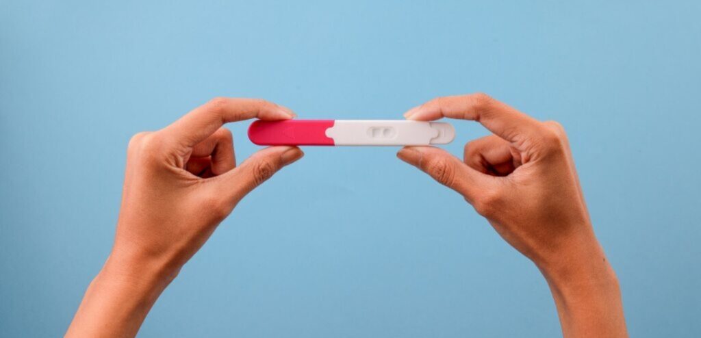 امرأة تمسك اختبار حمل