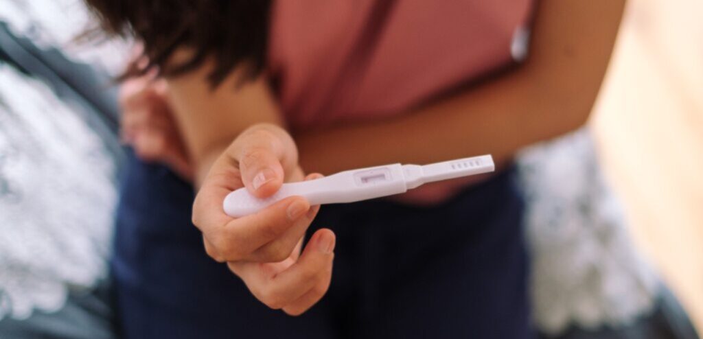 امرأة تمسك اختبار حمل