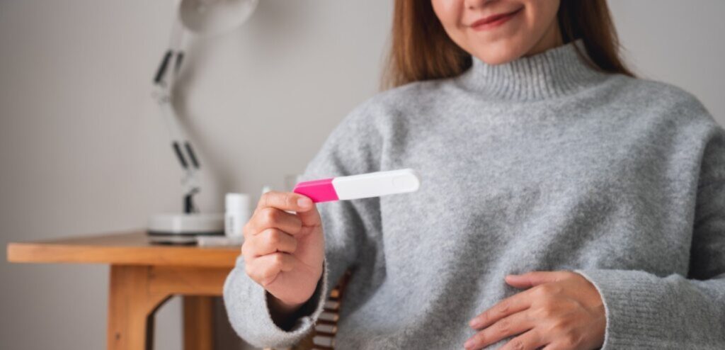 امرأة تمسك اختبار حمل