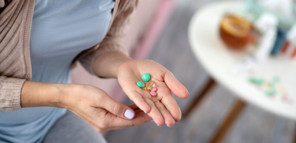 امرأة تمسك حبوب من الدواء