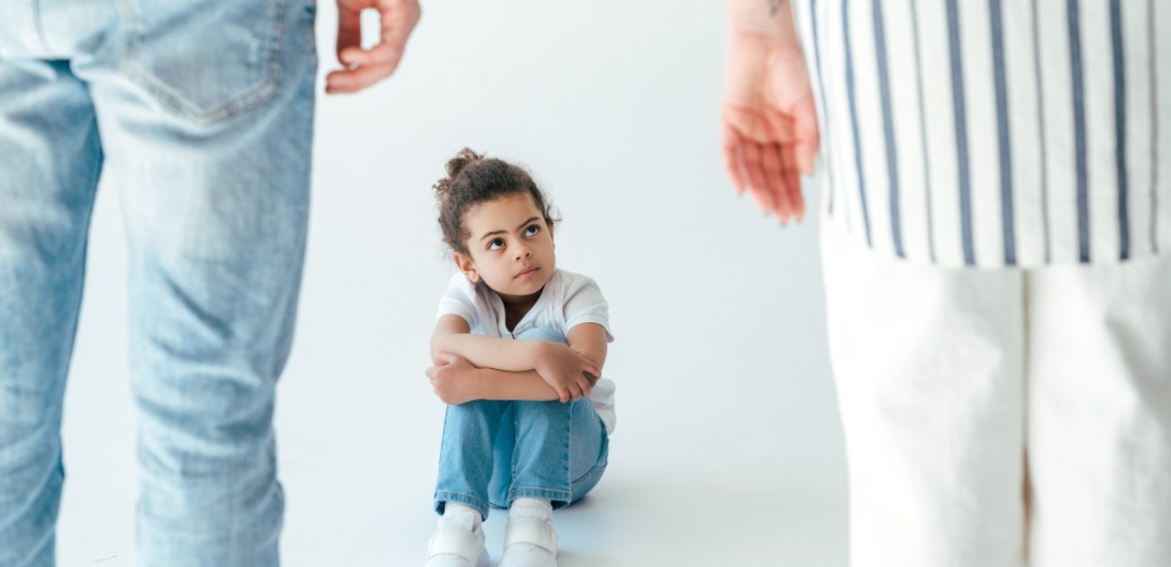 طفلة حزينة تنظر إلى والديها