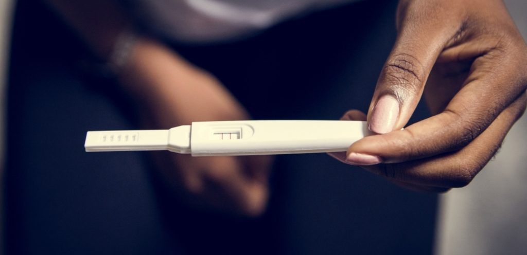 امرأة تمسك اختبار حمل