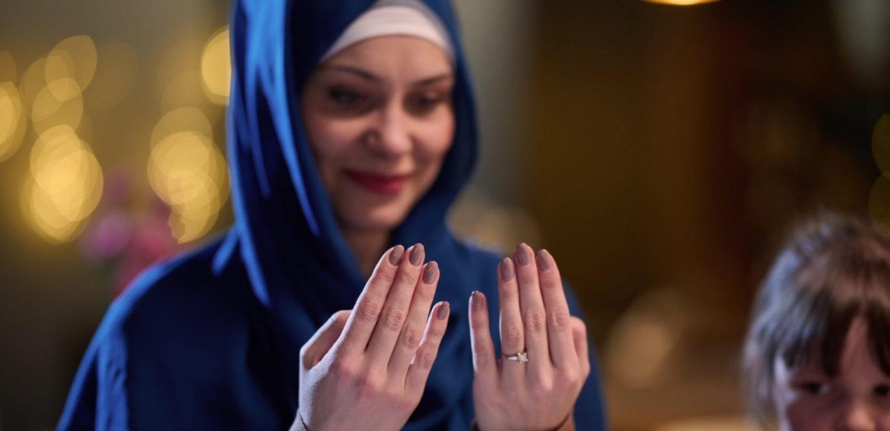 امرأة ترفع يديها للدعاء