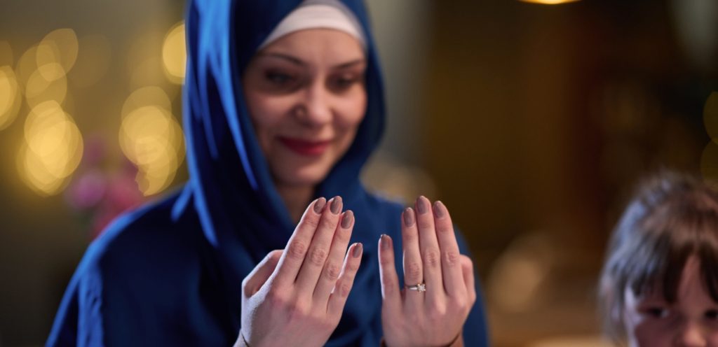 امرأة ترفع يديها للدعاء