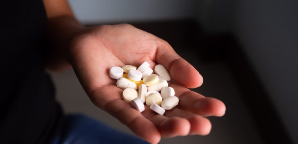 امرأة تمسك حبوب من الدواء