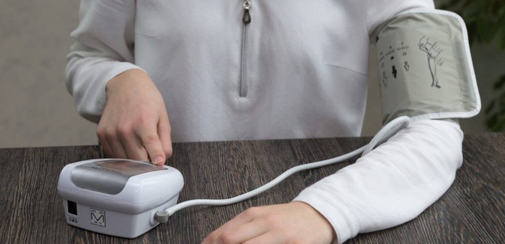 امرأة تستخدم آلة ضغط الدم