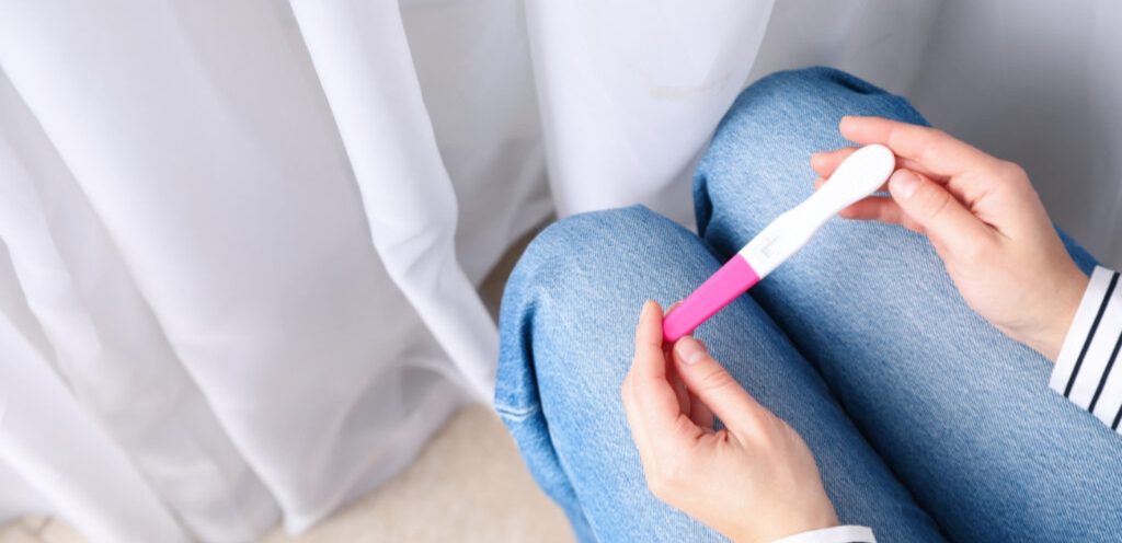 امرأة تمسك اختبار حمل