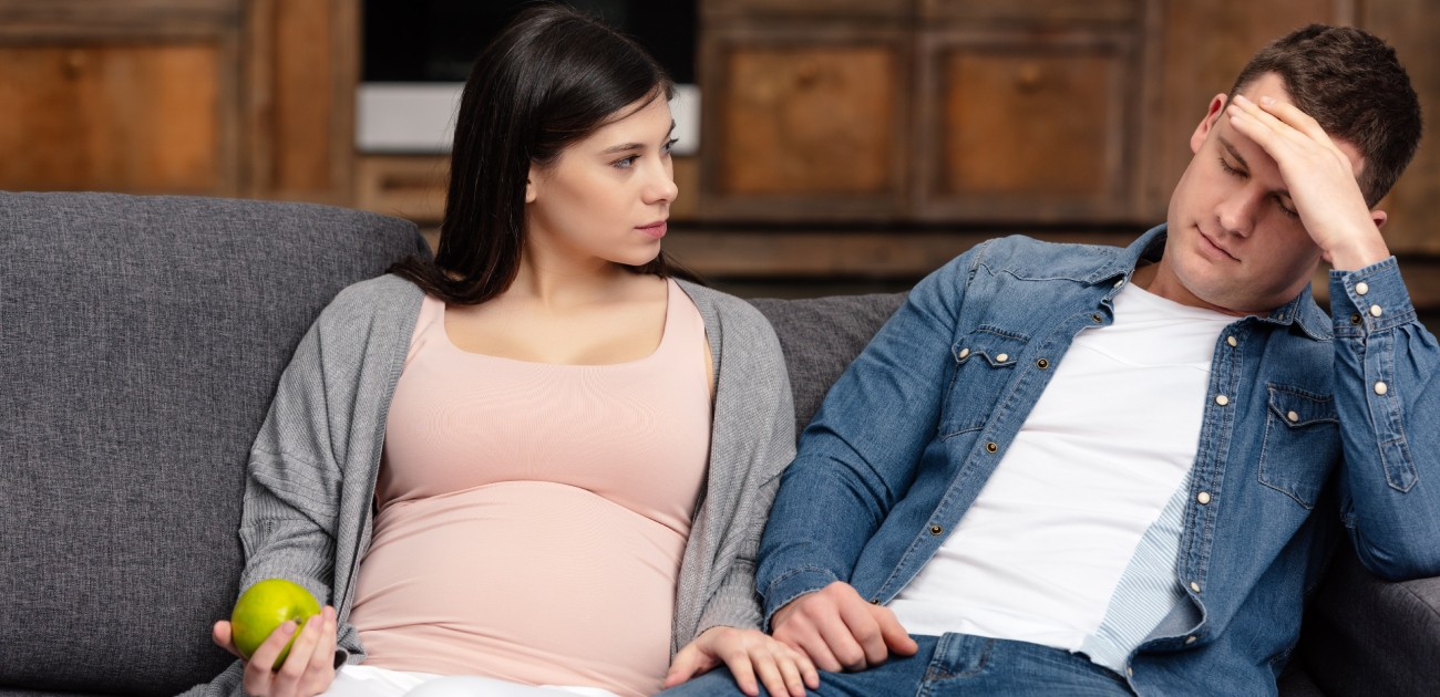 امرأة حامل تنظر إلى زوجها الحزين