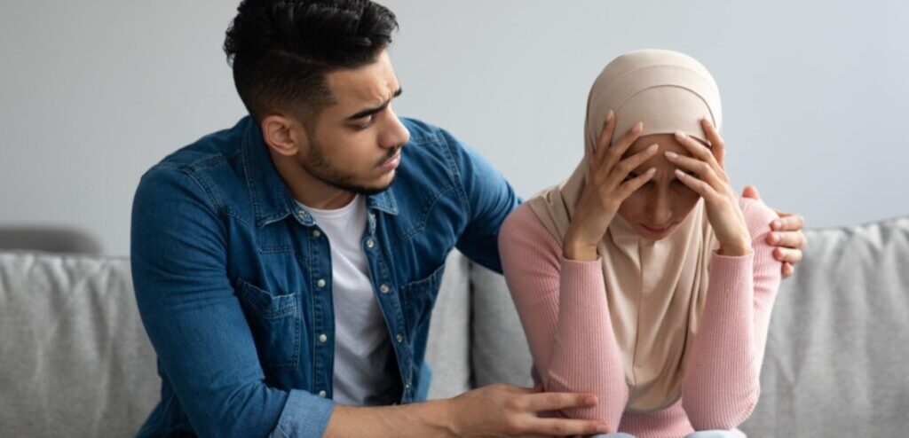 امرأة حزينة ورجل يحاول مواساتها
