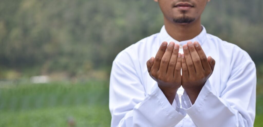 رجل يرفع يديه للدعاء
